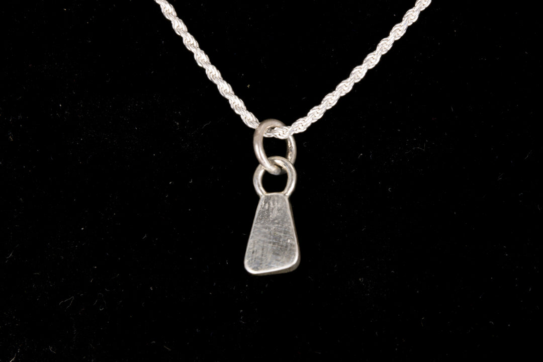 The back of a Blue faced Australian Boulder Opal set in sterling silver on a silver chain on a black background