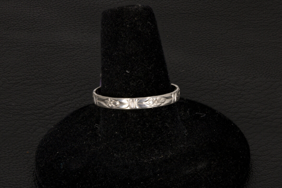 Purple charoite Ring, prong set in sterling silver on a black stand floral band view