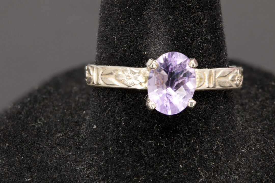 Faceted oval cut Amethyst ring set in sterling silver with a flower ring band, size 8.5 front view