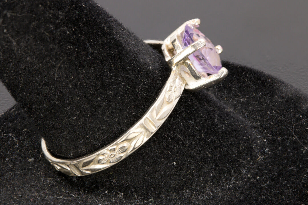 Faceted oval cut Amethyst ring set in sterling silver with a flower ring band, size 8.5 left side view