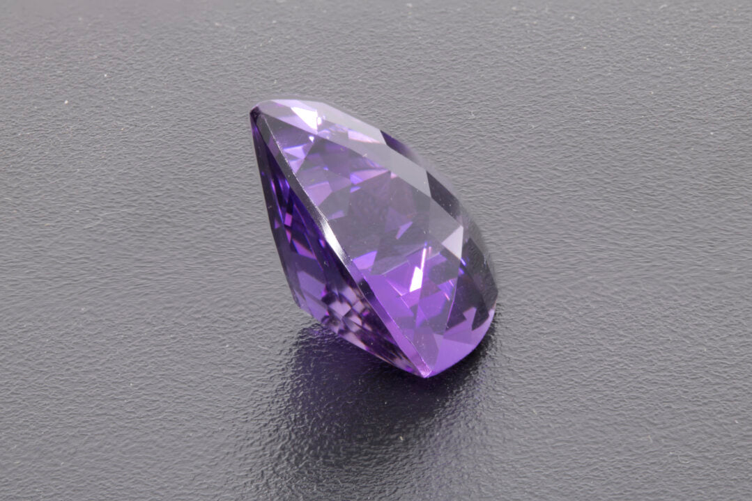 Faceted Trillion checker cut Amethyst, size 11.7 ct. and is 17.9 mm across each side, left side photo