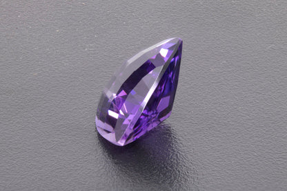 Faceted Trillion checker cut Amethyst, size 11.7 ct. and is 17.9 mm across each side, right side view