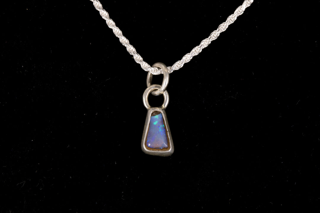 Blue faced Australian Boulder Opal set in sterling silver on a silver chain on a black background