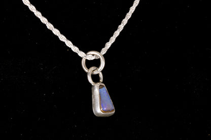 Blue faced Australian Boulder Opal set in sterling silver on a silver chain on a black background