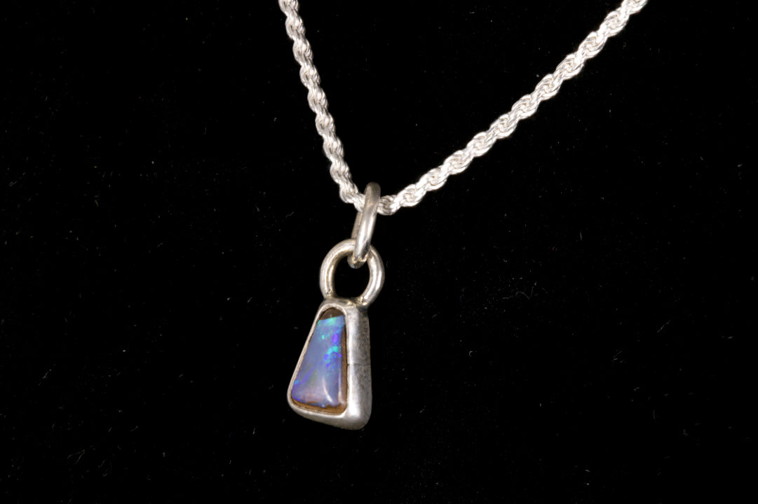 Blue faced Australian Boulder Opal set in sterling silver on a silver chain on a black background