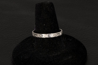 Purple charoite Ring, prong set in sterling silver on a black stand floral band view