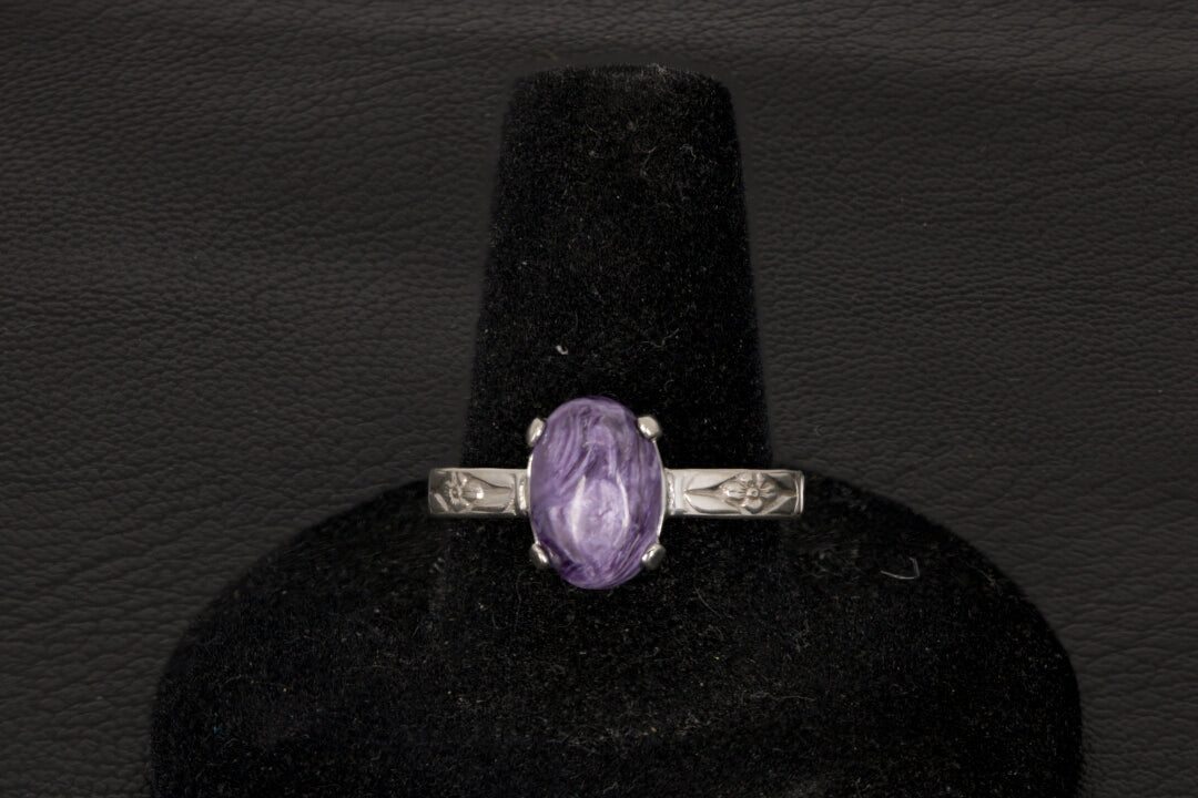 Purple charoite Ring, prong set in sterling silver on a black stand