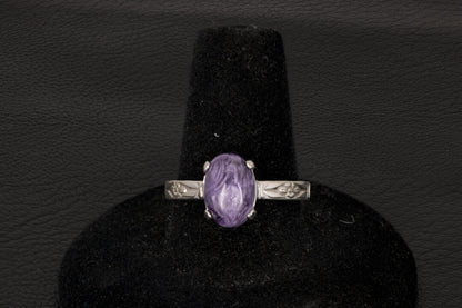Purple charoite Ring, prong set in sterling silver on a black stand