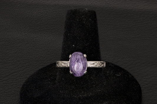 Purple charoite Ring, prong set in sterling silver on a black stand