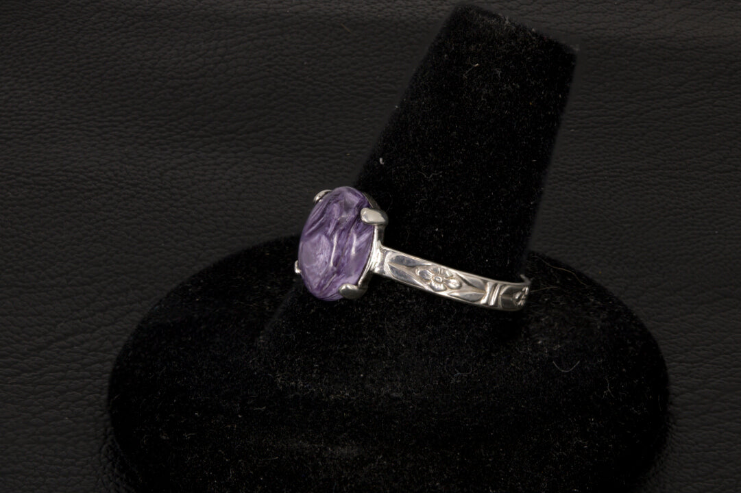 Purple charoite Ring, prong set in sterling silver on a black stand