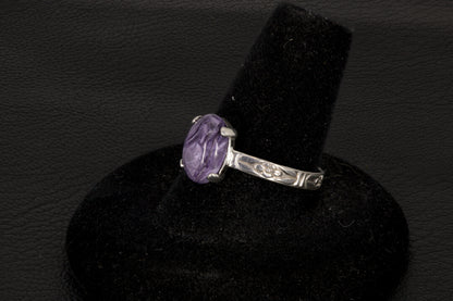 Purple charoite Ring, prong set in sterling silver on a black stand