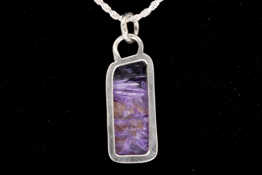 Charoite Rectangle With Dark Purple Cap Set In Sterling Silver on black background, back view.