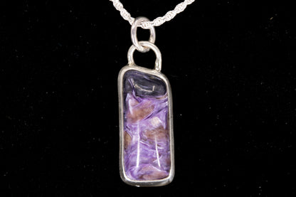 Charoite Rectangle With Dark Purple Cap Set In Sterling Silver on black background, front view.