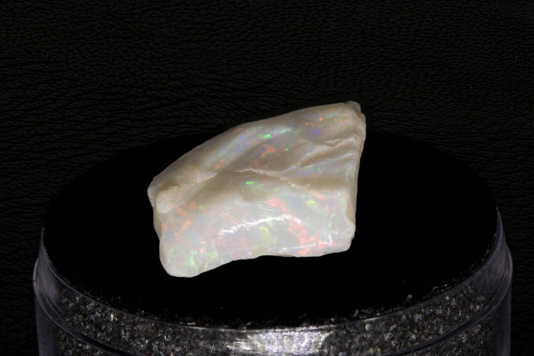 Coober Pedy rough opal setting on a black stand