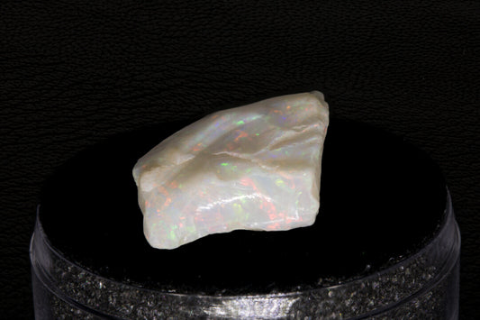 Coober Pedy rough opal setting on a black stand