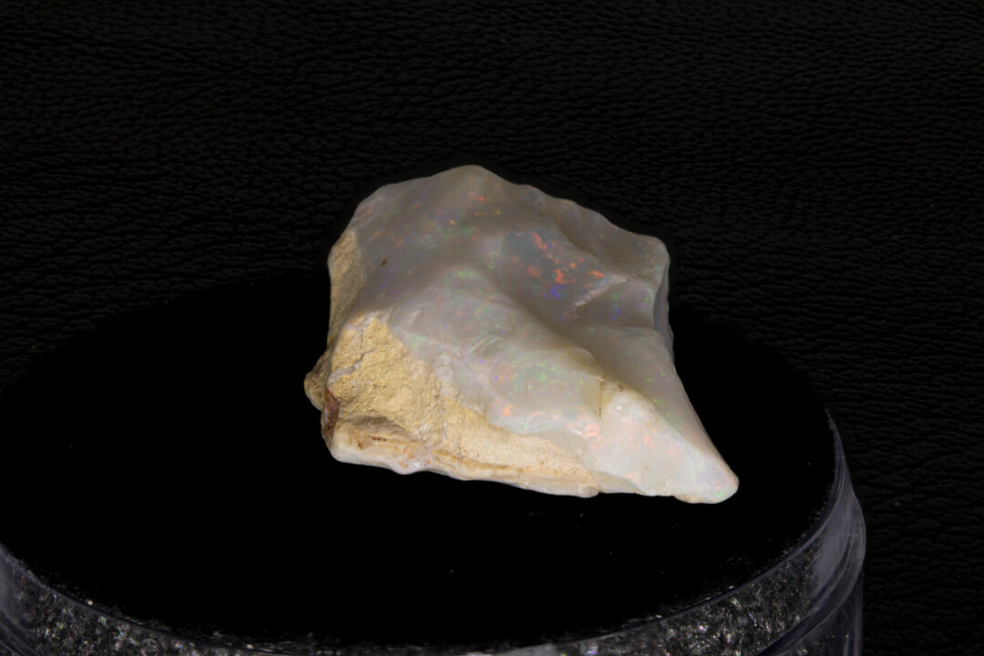 Coober Pedy rough opal setting on a black stand