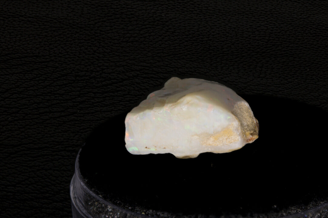 Coober Pedy rough opal setting on a black stand