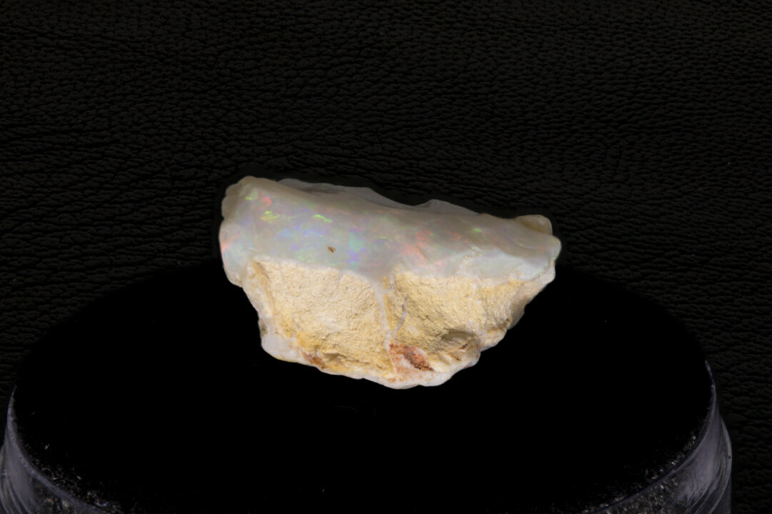 Coober Pedy rough opal setting on a black stand