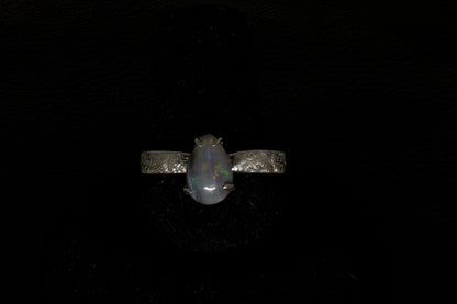 Ring with a pear-shaped opal stone on a dark background