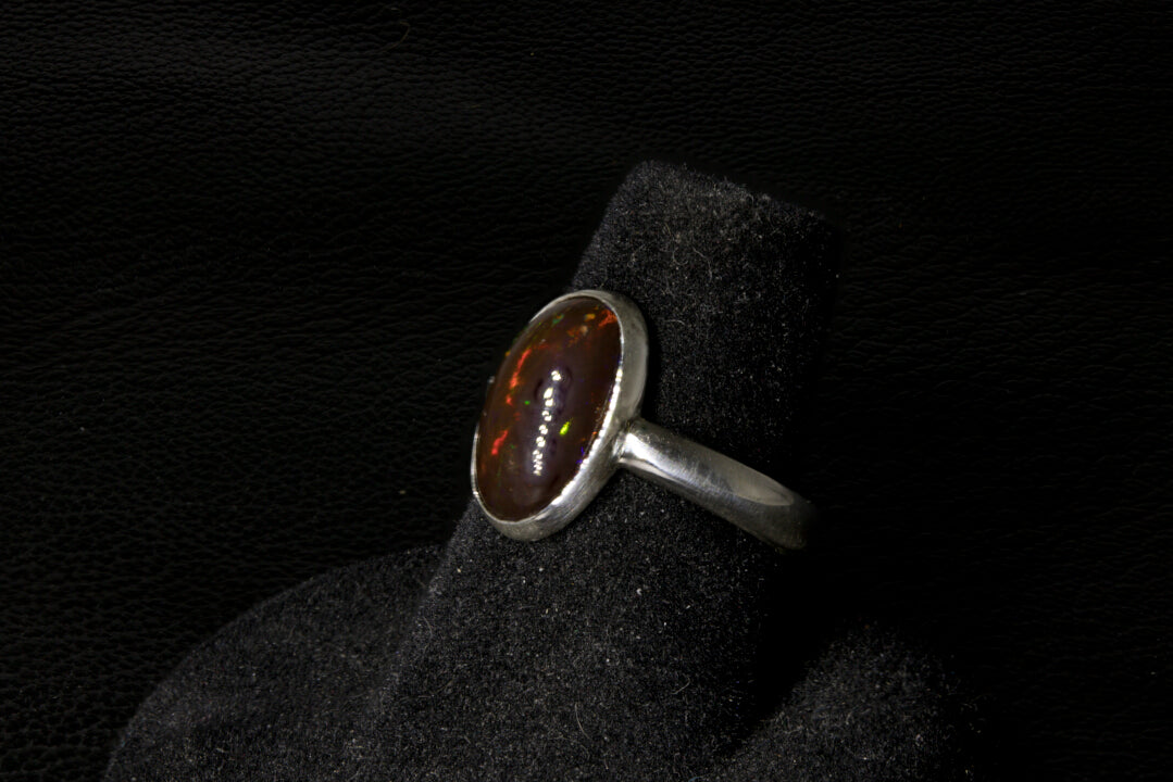 Silver ring with a brown gemstone on a black background