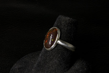 Silver ring with a brown gemstone on a black background