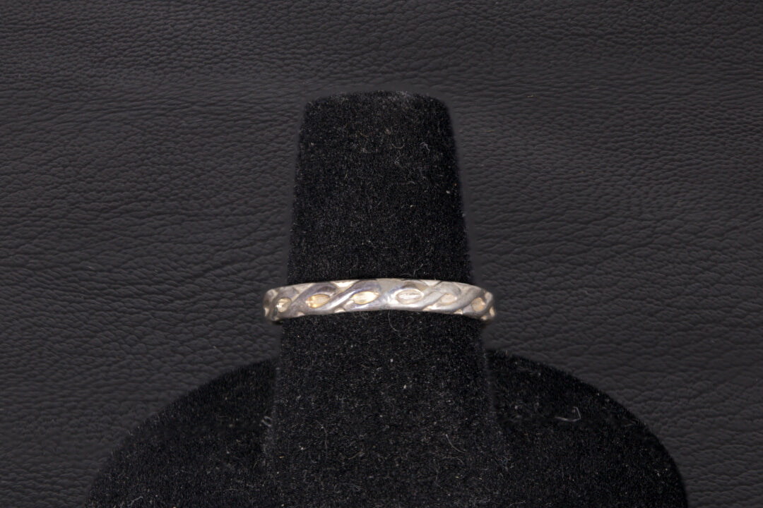 Green Jade ring set in sterling silver with a decorative infinity ring band on a black stand Band view only