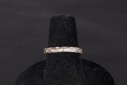 Green Jade ring set in sterling silver with a decorative infinity ring band on a black stand Band view only