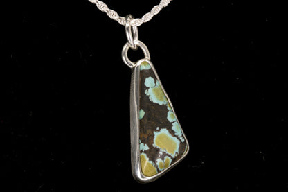 Necklace with a pendant featuring a natural stone design on a black background right side view