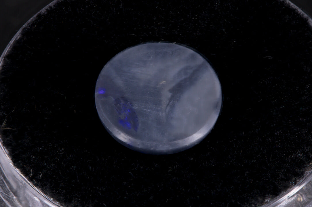 Round Lightning Ridge Black Opal on a black background back view