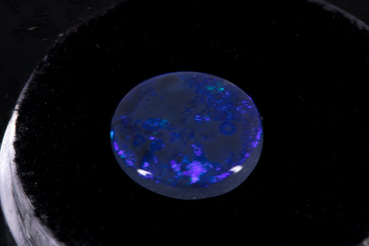 Round Lightning Ridge Black Opal on a black background