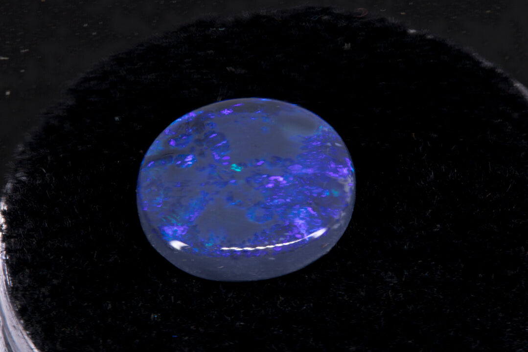 Round Lightning Ridge Black Opal on a black background