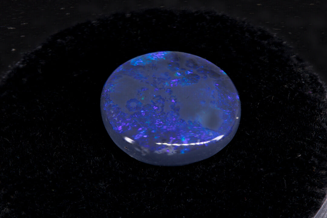 Round Lightning Ridge Black Opal on a black background