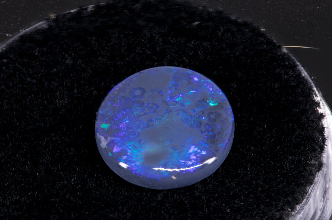 Round Lightning Ridge Black Opal on a black background