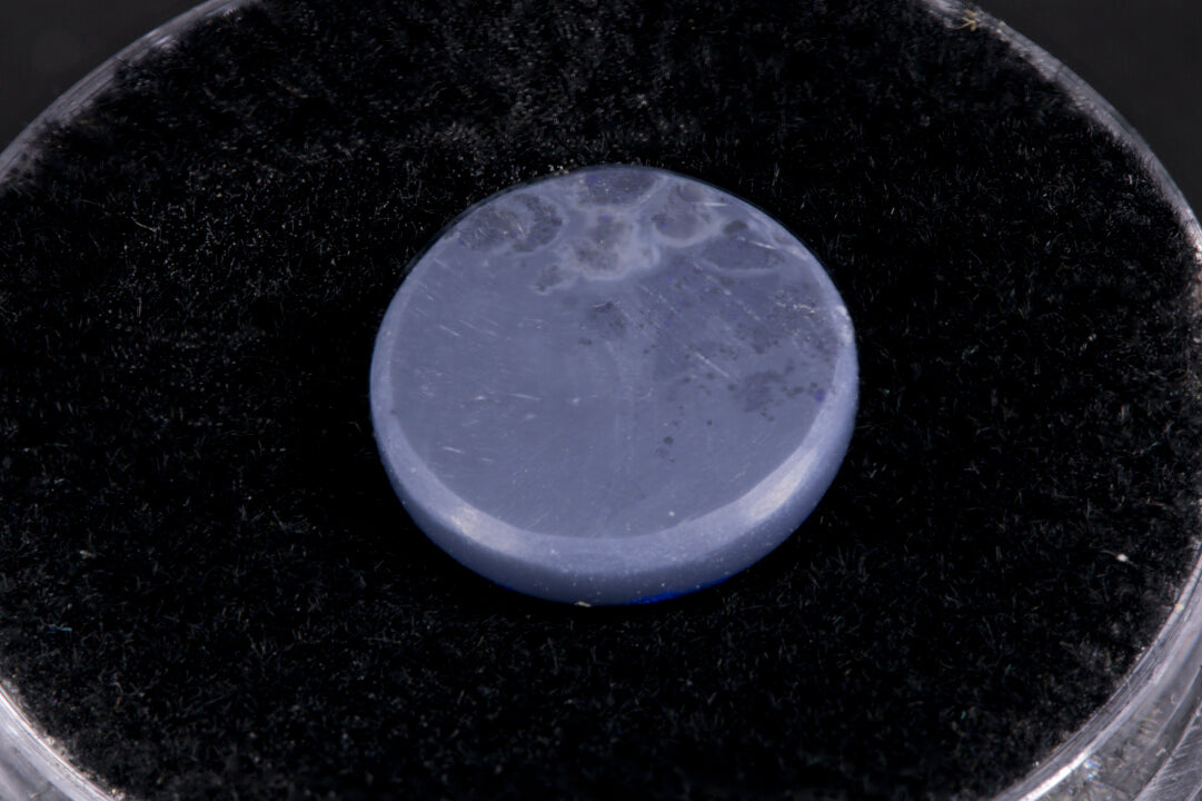 Lightning Ridge Black Opal with purple flash on a black background back view