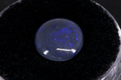 Lightning Ridge Black Opal with purple flash on a black background