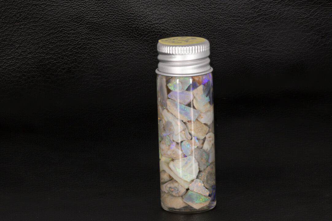 Lightning Ridge rough opal chips and small stones in a jar.