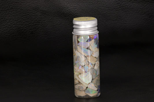 Lightning Ridge rough opal chips and small stones in a jar.