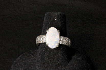 Silver ring with a large Opal gemstone on a black stand