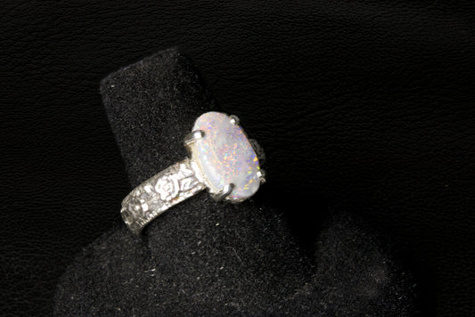 Silver ring with a large Opal gemstone on a black stand