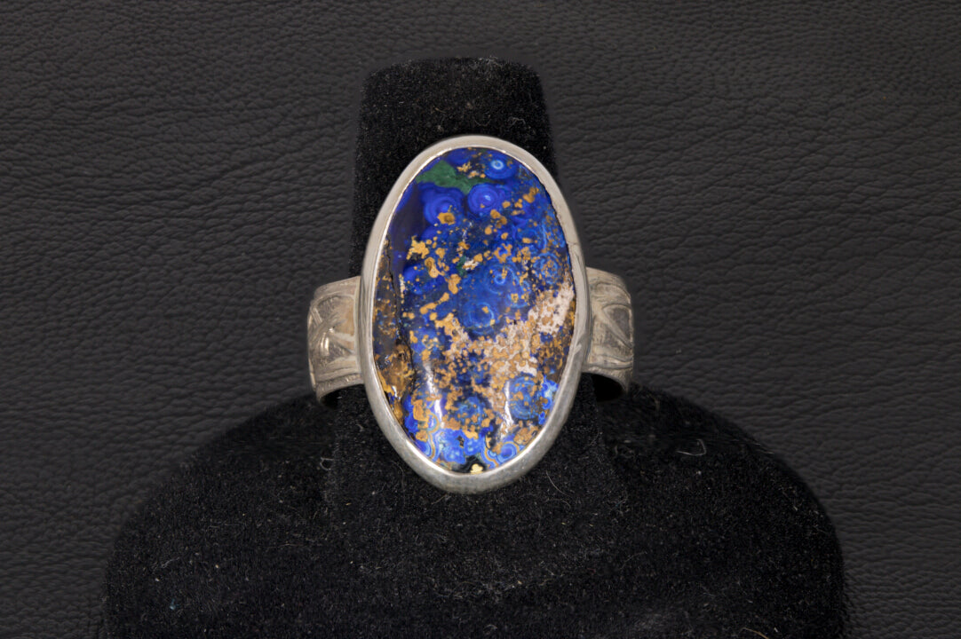 Blue Azurite Oval Ring with decorative flower ring band set in sterling silver on a black background