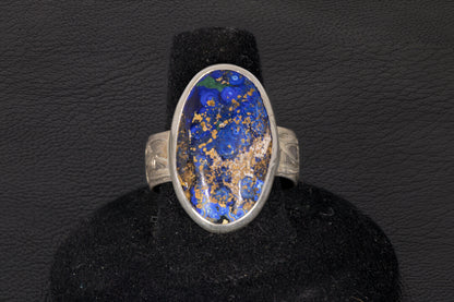 Blue Azurite Oval Ring with decorative flower ring band set in sterling silver on a black background
