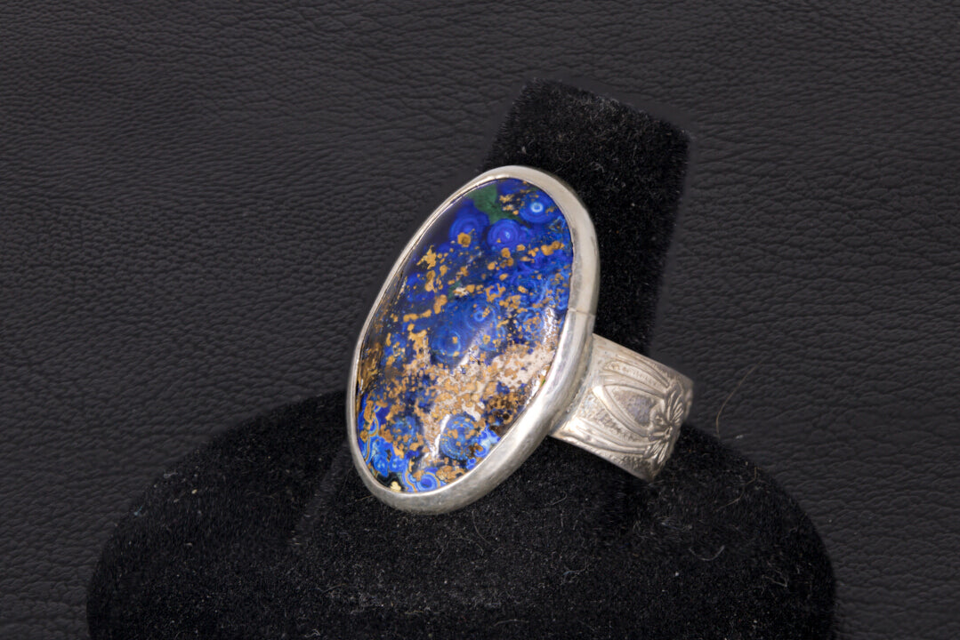 Blue Azurite Oval Ring with decorative flower ring band set in sterling silver on a black background