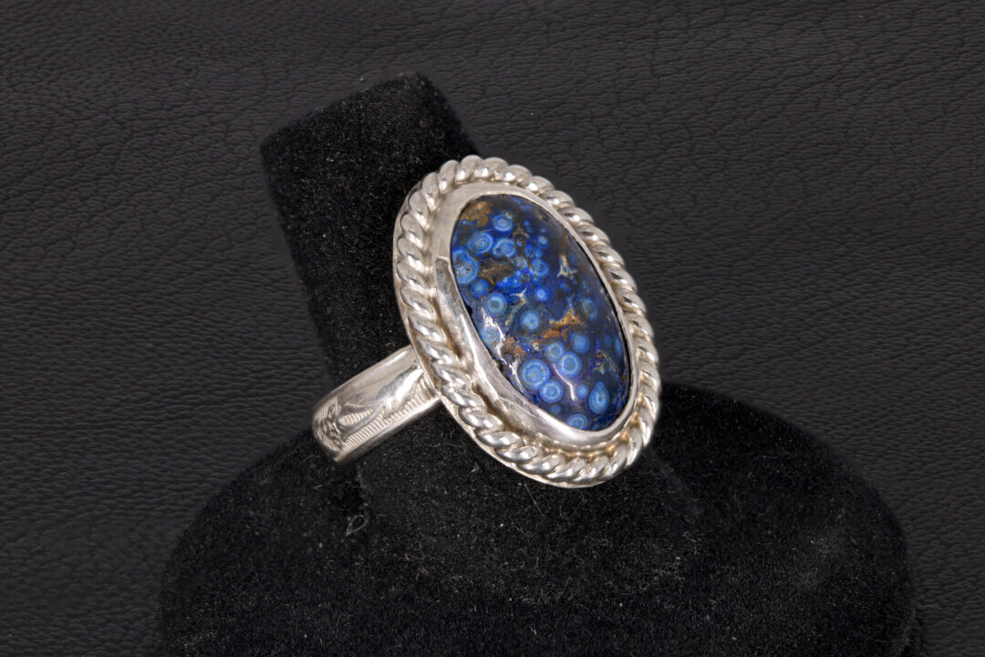 Silver ring with a blue stone on a black background