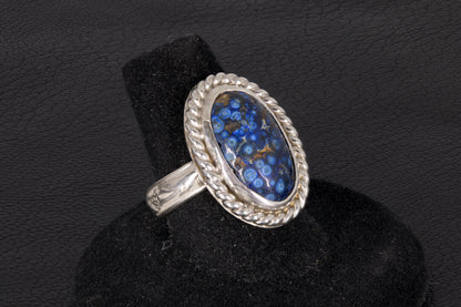 Silver ring with a blue stone on a black background
