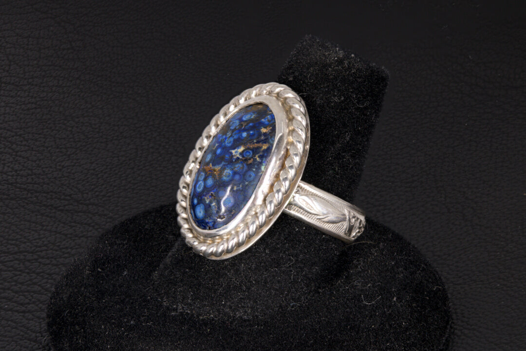 Silver ring with blue stone on a black background
