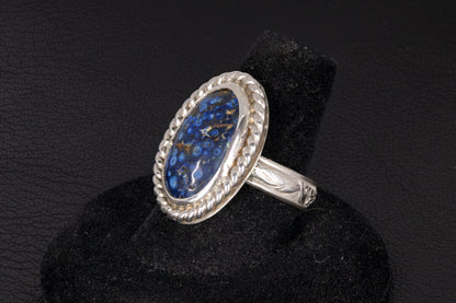 Silver ring with blue stone on a black background