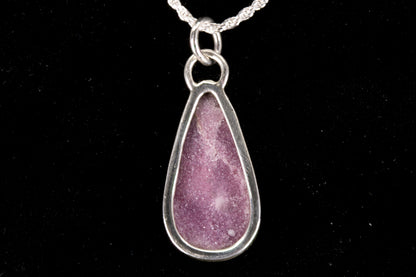 Pink Lepidolite pendant set in sterling silver on a black background back view