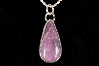 Pink Lepidolite pendant set in sterling silver on a black background front view