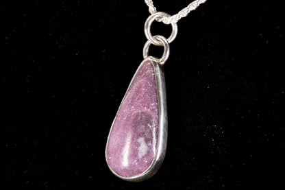 Pink Lepidolite pendant set in sterling silver on a black background left side view