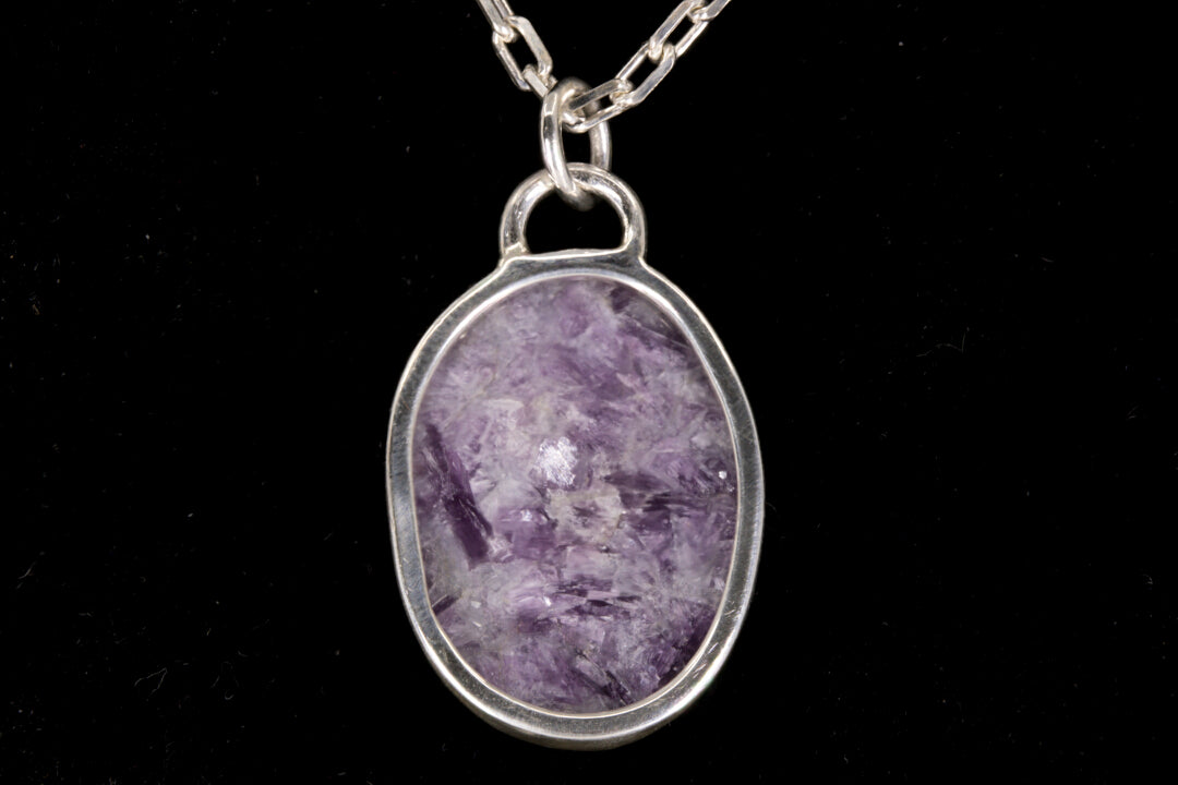 Purple Lepidolite pendant on a silver chain against a black background open back view